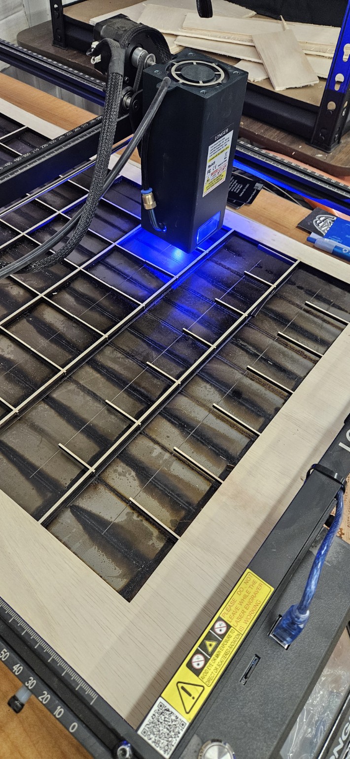 Laser engraver producing a batch of black metal cards