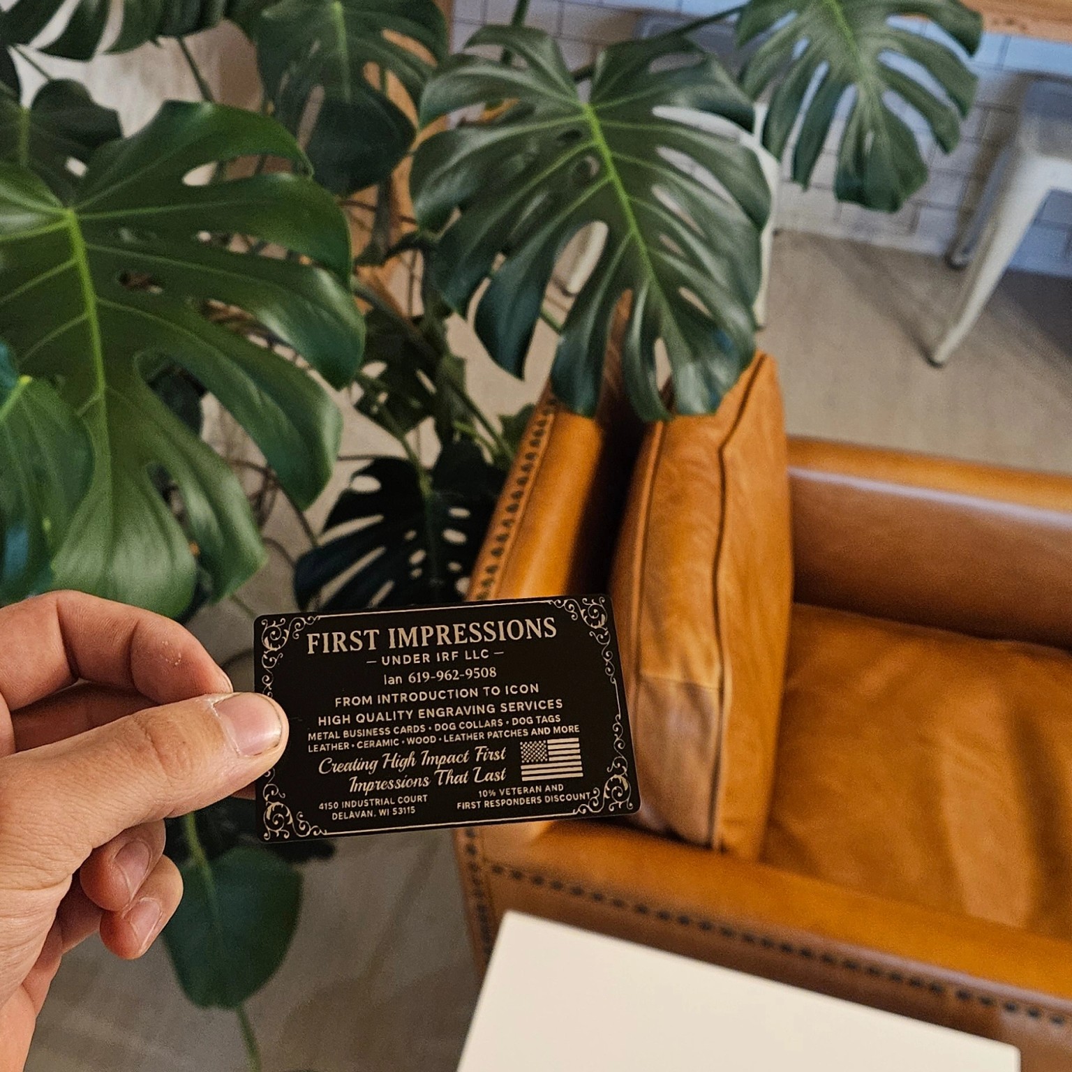 First Impressions engraved metal business card held in hand